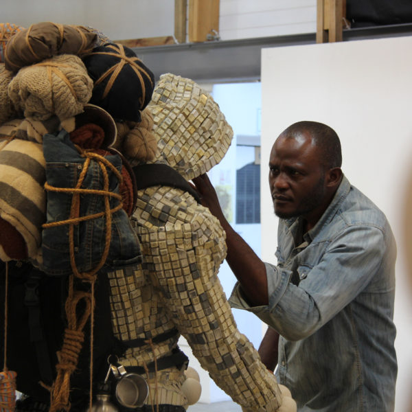 Maurice checking his sculpture created from e-waste, including used and discarded keyboards